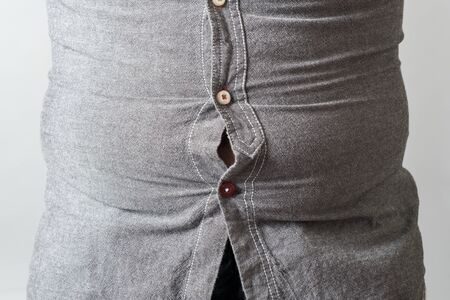 Man with overweight. Concept of beer belly. Isolated on gray backgroundの写真素材