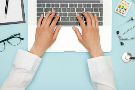 Female doctor working at workplace with laptop and medical equipment. Healthcare concept