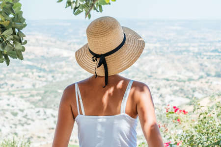 Beautiful woman wearing straw hat looking valley viewの写真素材