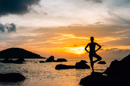 Silhouette of woman anainst sunset on the seaの写真素材