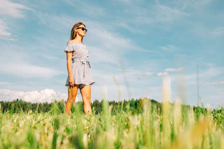 Cheerful girl walks outside in a meadowの写真素材