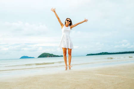 Freedom happy woman with raised arms on the beach at sunny day. Happiness and freedom conceptの写真素材