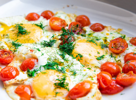 Fried eggs with cherry tomatoes close-up