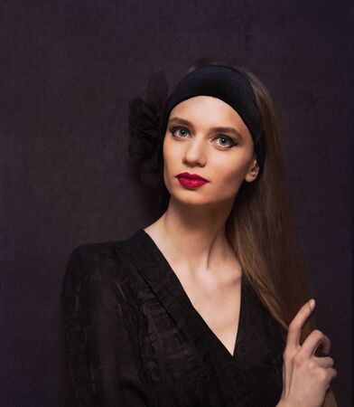 Portrait of a beautiful woman in vintage style over old dark fashioned wallの写真素材