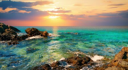 Seascape panorama of rocks in the sea at sunsetの写真素材