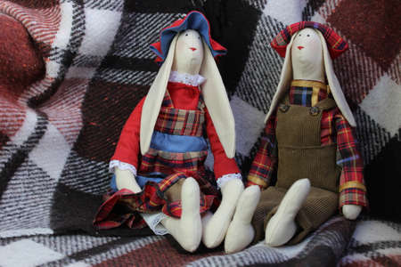 Handmade dolls.Hare tilde sitting on a plaid backgroundの写真素材