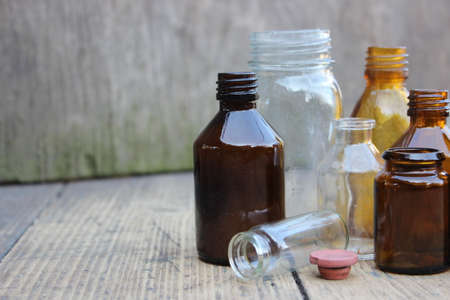 Multicolored glass pharmacy bottles on wooden boardsの写真素材
