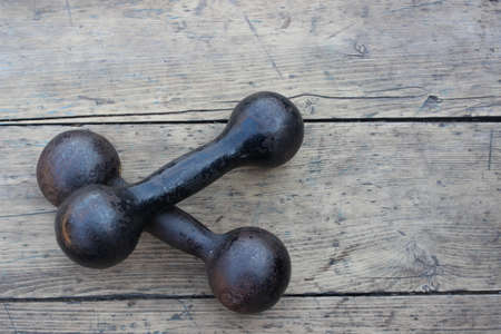 Sports metal dumbbell on a background of a wooden boardの写真素材