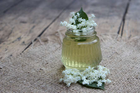 Glass jar of natural bee honey and elder flowersの写真素材