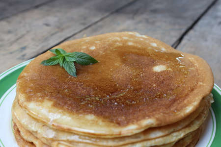 Pancake cake with honey on plate on the boards