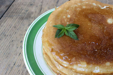 Pancake cake with honey on plate on the boards