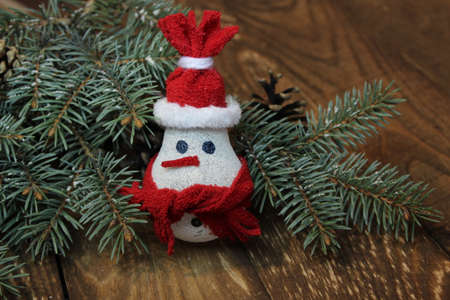 Snowman made from light bulb near Christmas tree