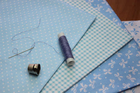 Multicolored cuts of fabric with coils of thread on the background of boards