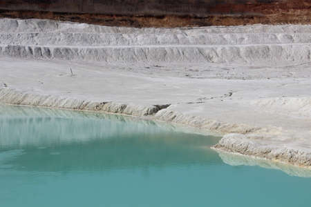 Clay mining. Beautiful background of white clay. Blue water.