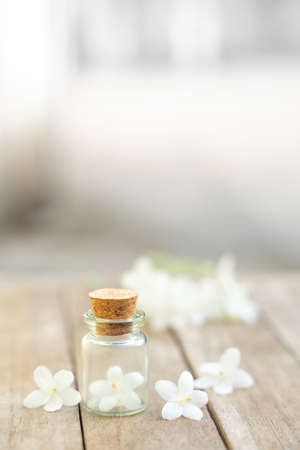 Glass bottles have small flowers on the wooden floor.の写真素材