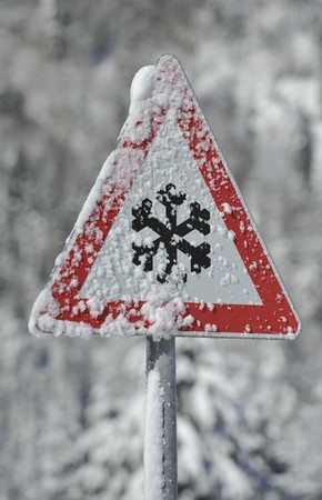 a sign warns against danger of avalanche and snowの写真素材