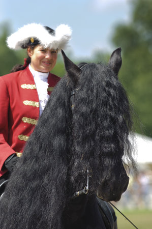 MUNICH, GERMANY - JUNE 4:  portrait of Friese horse with styled long mane and baroque rider while a public show at international equestrian challenge -Pferd International 2011- at June 4, 2011 in Munich, Germanyのeditorial素材