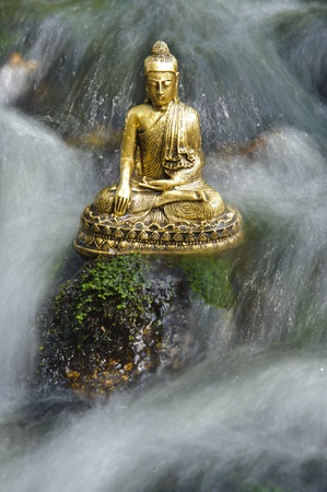 buddha figure is sitting in water cascadeの写真素材