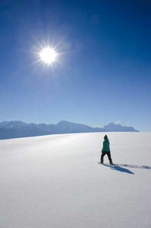 single woman with snow shoes on a walk in fresh snow powder in bavaria, germanyの写真素材