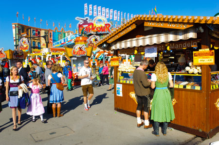 MUNICH, GERMANY - SEPTEMBER 23, 2014: The Oktoberfest in Munich is the biggest beer festival of the world. The visitors have lot of fun with many amusement huts and shops for food, gifts and souvenirs.のeditorial素材