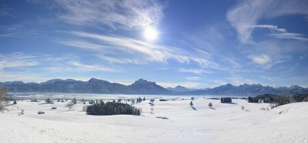 panorama landscape in Bavaria with alps mountains and lake Forggensee at winter with snowの写真素材