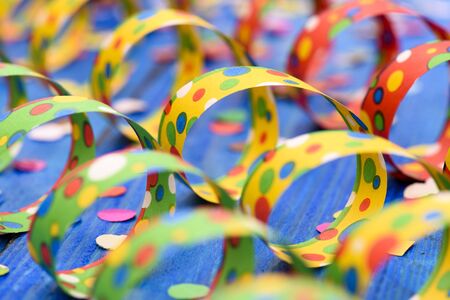colorful paper streamer at carnival party over blue background