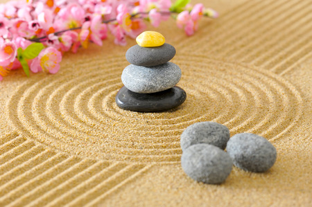 Japanese Zen garden with stacked stones in textured sandの写真素材