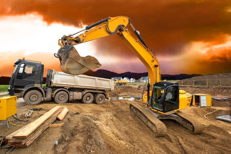 earth mover and excavator at work in construction siteの写真素材