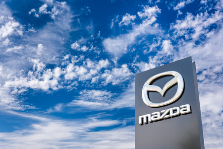 AUGSBURG, GERMANY â JUNE 16, 2022: Advertising sign of the car brand MAZDA in front of a sky with cloudsのeditorial素材