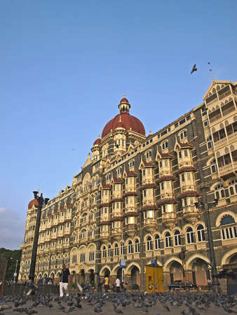 MUMBAI, INDIA - JULY 18, 2008: Crowding of pigeons are stepping in front of the Taj Hotel, a renown...