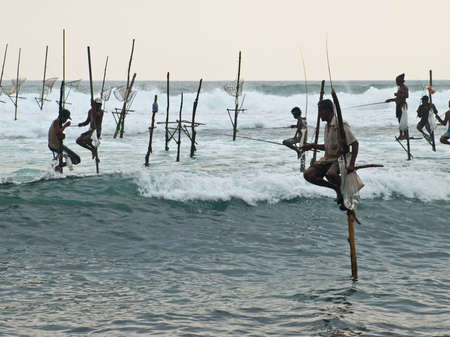 KOGGALA, SRI LANKA-OCTOBER 22, 2009: The local fishermen are fishing in unique style. The standing on the single timber pole can only found in this Indian ocean in Koggala, Sri Lanka. のeditorial素材