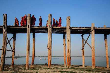 Mandalay, Myanmar-JANUARY 6: The Burmese monks are walking across U Bein bridge. The longest teak...