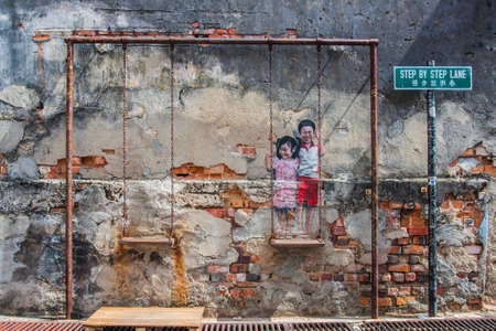 Georgetown, Penang, Malaysia - February 19, 2015: "Children on the Swing" street art on wall by local artist Louis Ganのeditorial素材