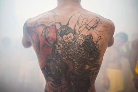 Phuket, Thailand - October 18, 2015: Art of body tattoo on the back of young fellow, in the vegetarian festival.のeditorial素材