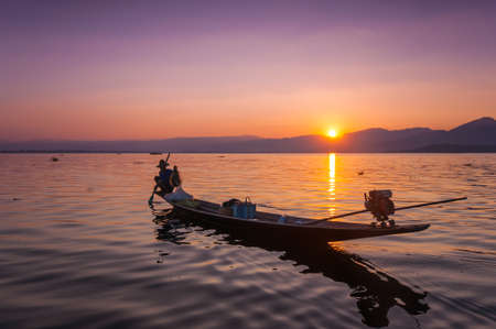Local fishermen are fishing by boat in unique style, Inle lake, Myanmarの写真素材