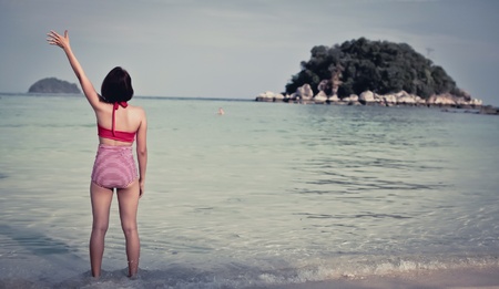 Woman say hi on the beach の素材