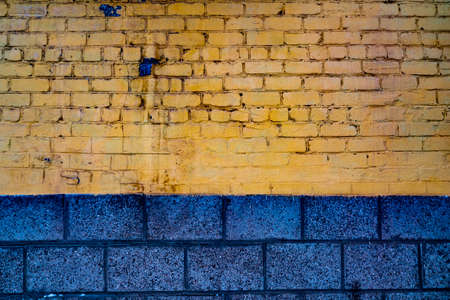 Blue and yellow brick wall rough backgroundの写真素材