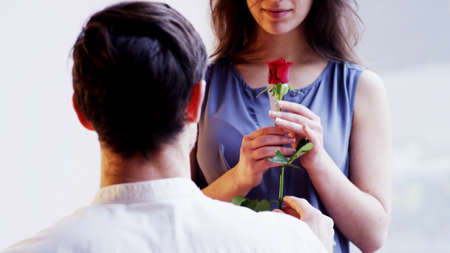 A Man Gives a Red Rose to a Womanの写真素材