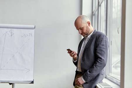 Businessman Starting a Phone Call Near the Windowの写真素材