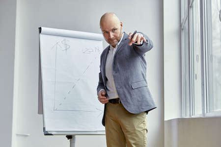 Bald Businessman Poiting at Something With a Markerの写真素材