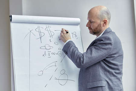 Bald Man Drawing an Arrow on the Board During a Lecture