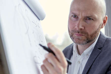 Businessman Holding a Pen and Looking at the Board