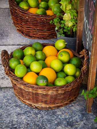 Lemons of various colors and shapes in a basketの写真素材