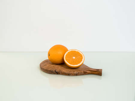 fresh yellow oranges on a wooden plank on a white backgroundの写真素材