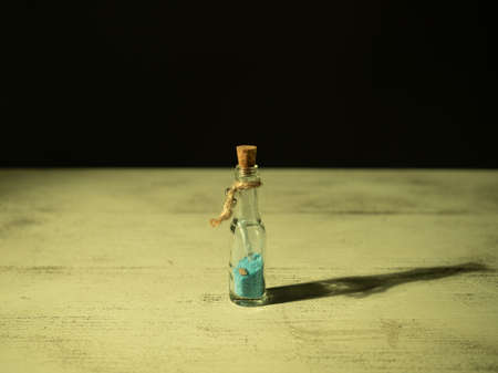 Bottle locked inside a rolled up letter, warm light, close-upの写真素材