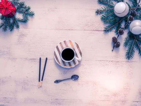 Christmas composition. Christmas gift, pine cones, fir branches on a wooden white background. Wooden decorations and a branch with pine cones, falling snow, Lay flat, top view, copy spaceの写真素材
