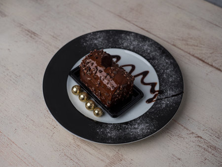 cake with chocolate cream on a plate decorated, view from above, wooden light background, warm...