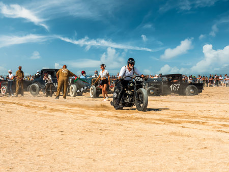 Ouistreham, Normandy, France, September 2021. NORMANDY BEACH RACE. Rider pushing the bike on the Ouistreham beach, old clothes, retro styleのeditorial素材