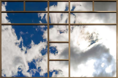 Clouds reflected in windows of modern office buildingの写真素材