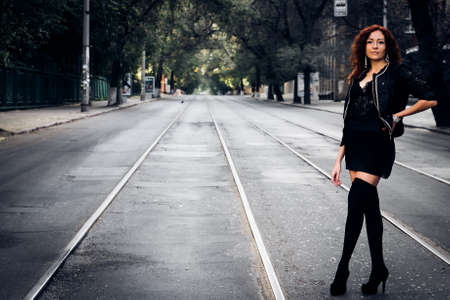 Cute girl with red hair on city roadの写真素材